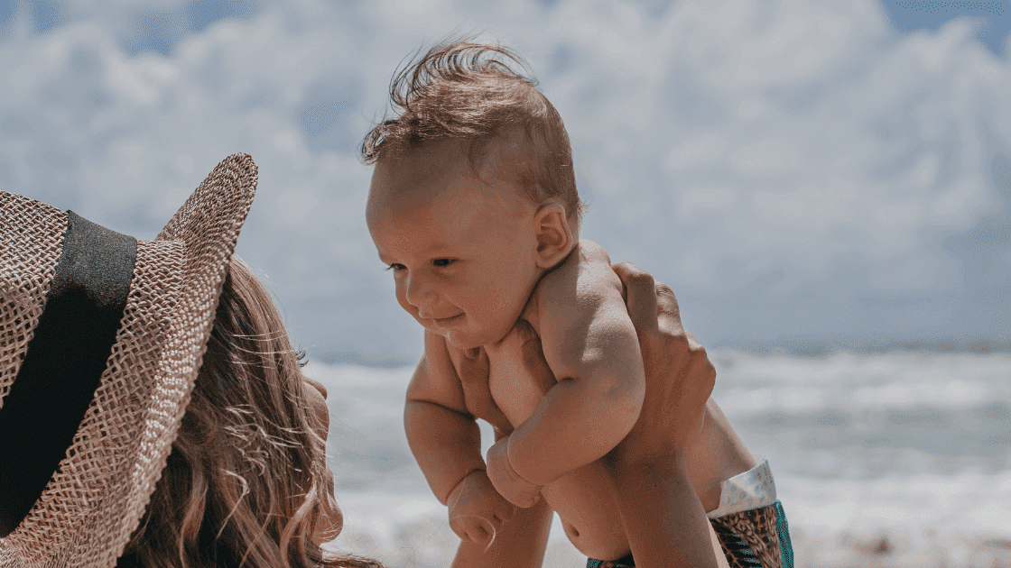 Mother holding her child at the beach.