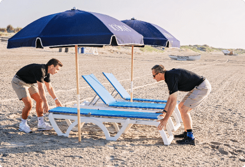 ICONA employees placing lounge chairs on the beach