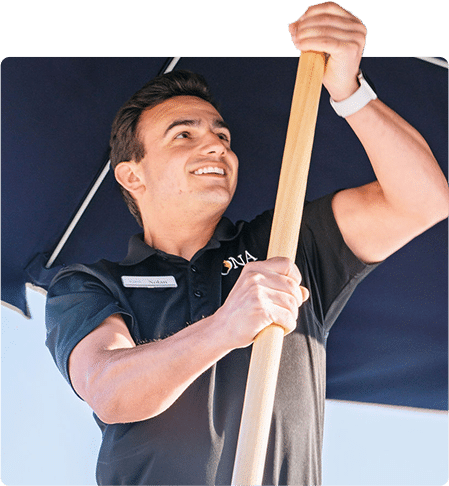 ICONA Resorts employee putting up a beach umbrella