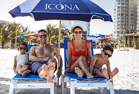 Family on ICONA lounge chairs outside of ICONA Diamond Beach