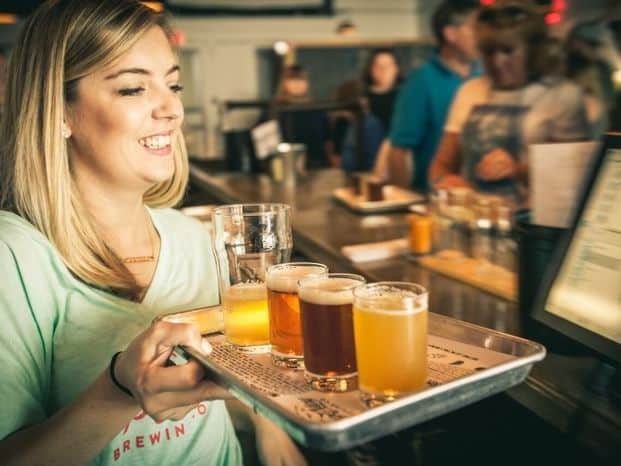 Server carrying trays of brews for the Cape May Brewery