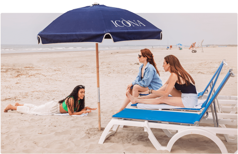 Friends lounging on the beach outside of ICONA Diamond Beach