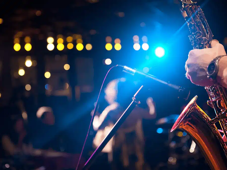 Person playing a saxophone into a microphone