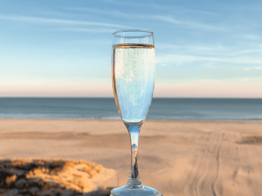 Wine glass on the beach for Wine, Dine & unwind package at ICONA Diamond Beach.