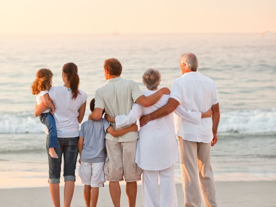 Family looking at the sunrise on the beach