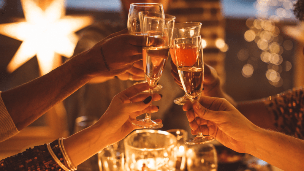 NYE party in Avalon: group of hands cheersing champagne and drinks at a party