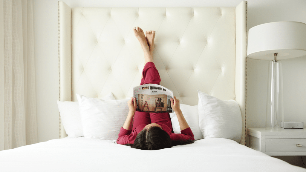 Woman reading the newspaper in a hotel bed