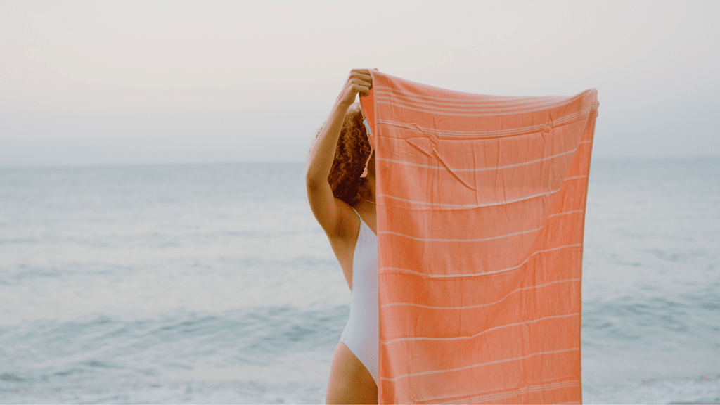 Woman holding up a monogrammed beach towel