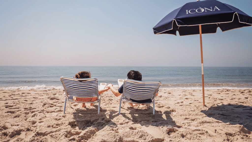 Couple lounging on the beach in their ICONA beach chairs